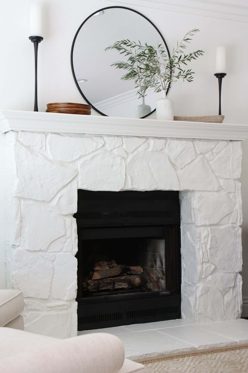 painted stone fireplace, white with white mantel and round mirror