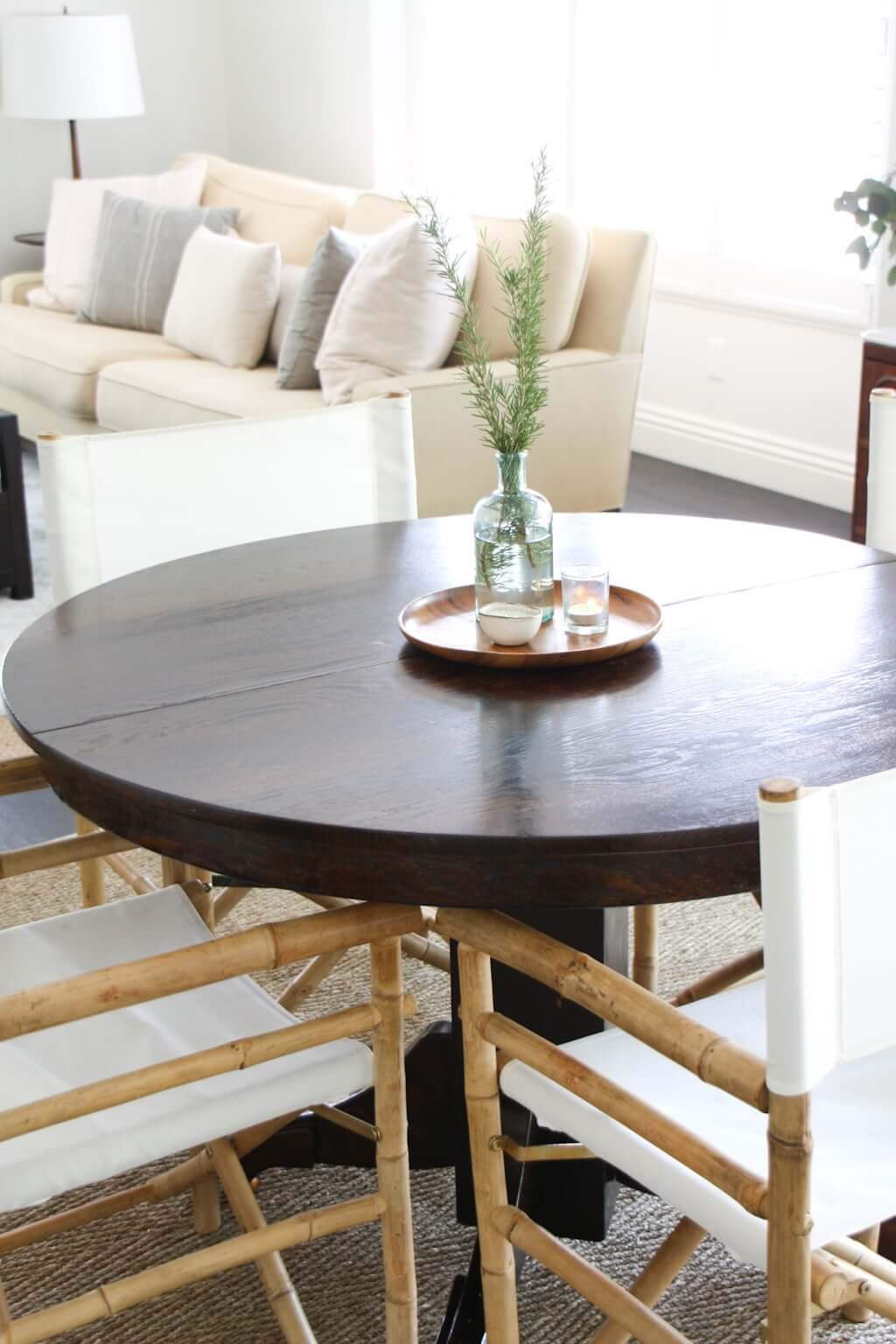 dark wood round dining table with four chairs and a centerpiece