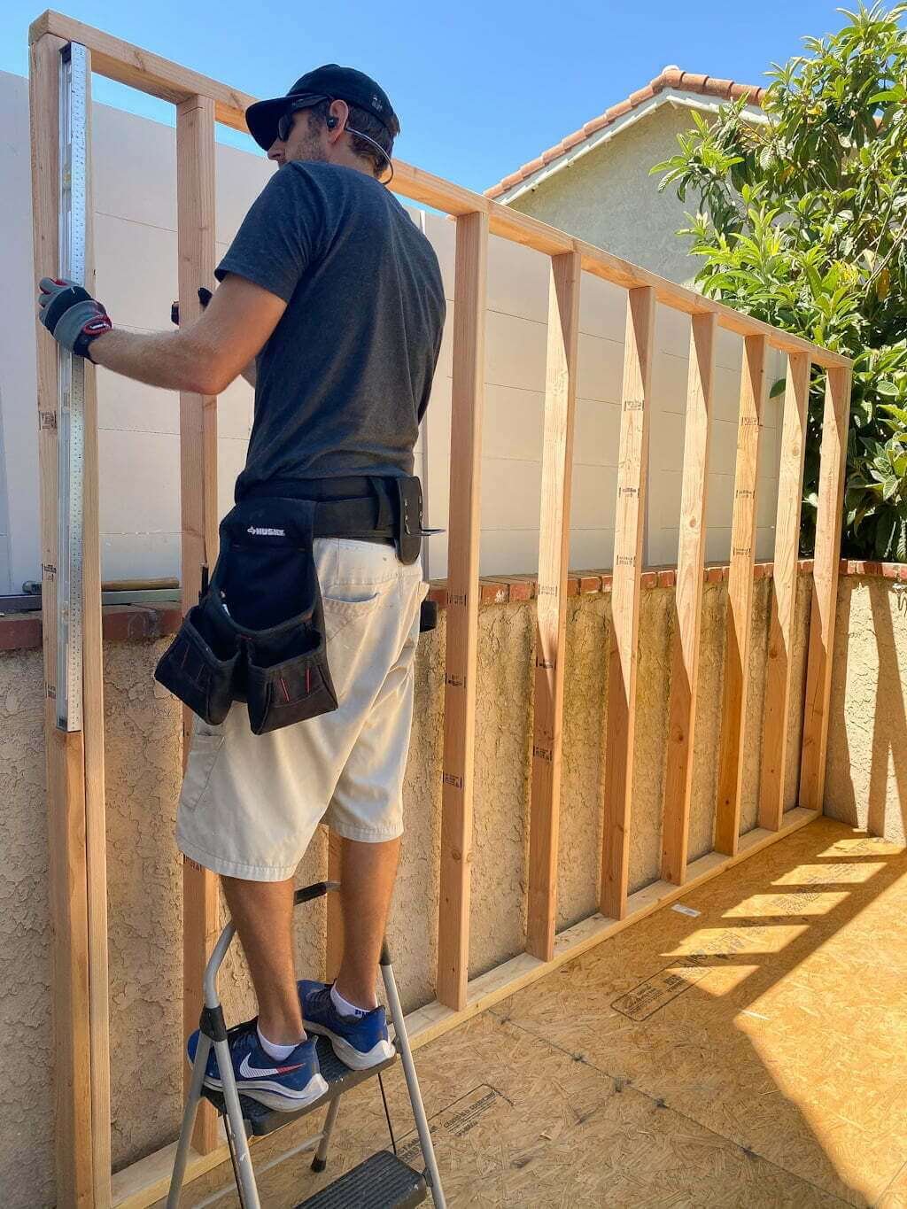 man building wooden wall of art studio shed