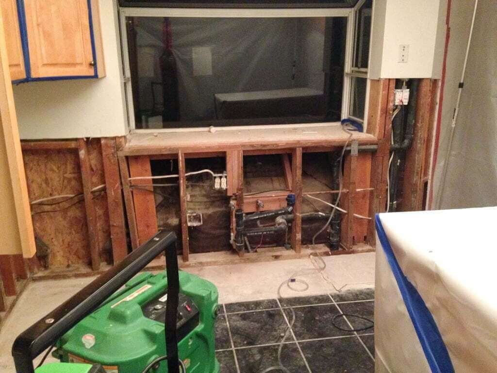 Kitchen demolished after mold removal with no lower cabinets or sink