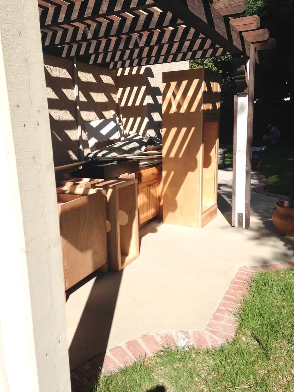 Cabinetry removed from kitchen sitting outside on patio