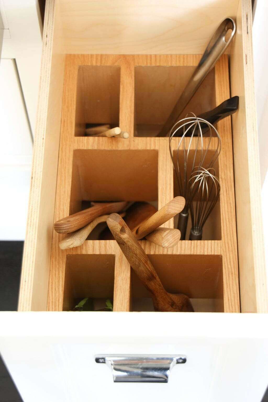 open drawer with various kitchen tools organized vertically in wood dividers