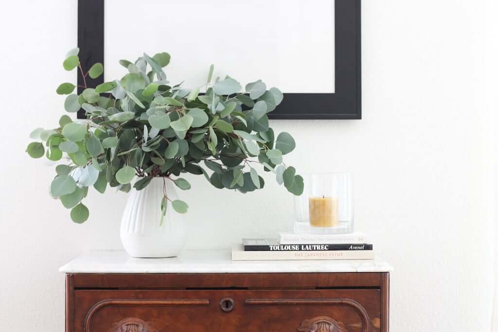 dining bureau styled with eucalyptus, candle, and books