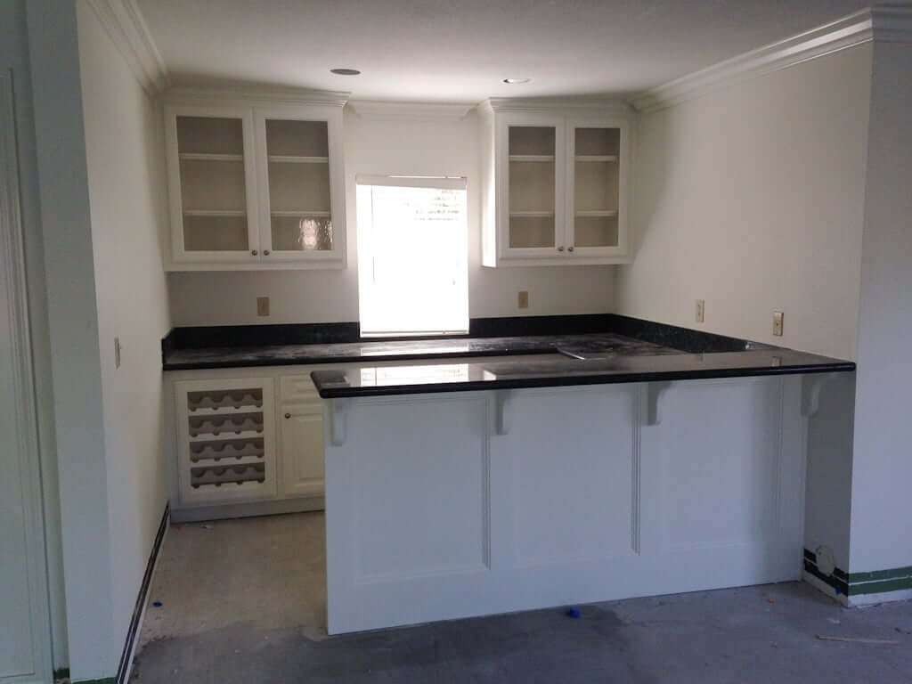 bar area with cabinets painted white