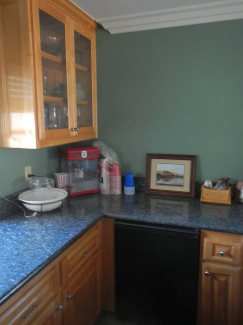 bar area with granite countertops and an upper wood cabinet with glass doors