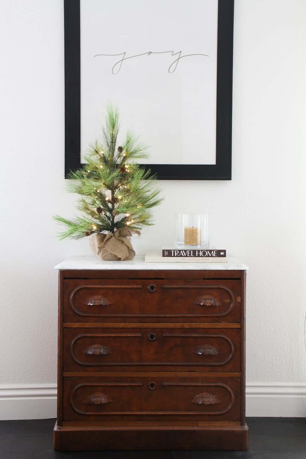 simple Christmas decor with small Christmas tree on dining buffet bureau