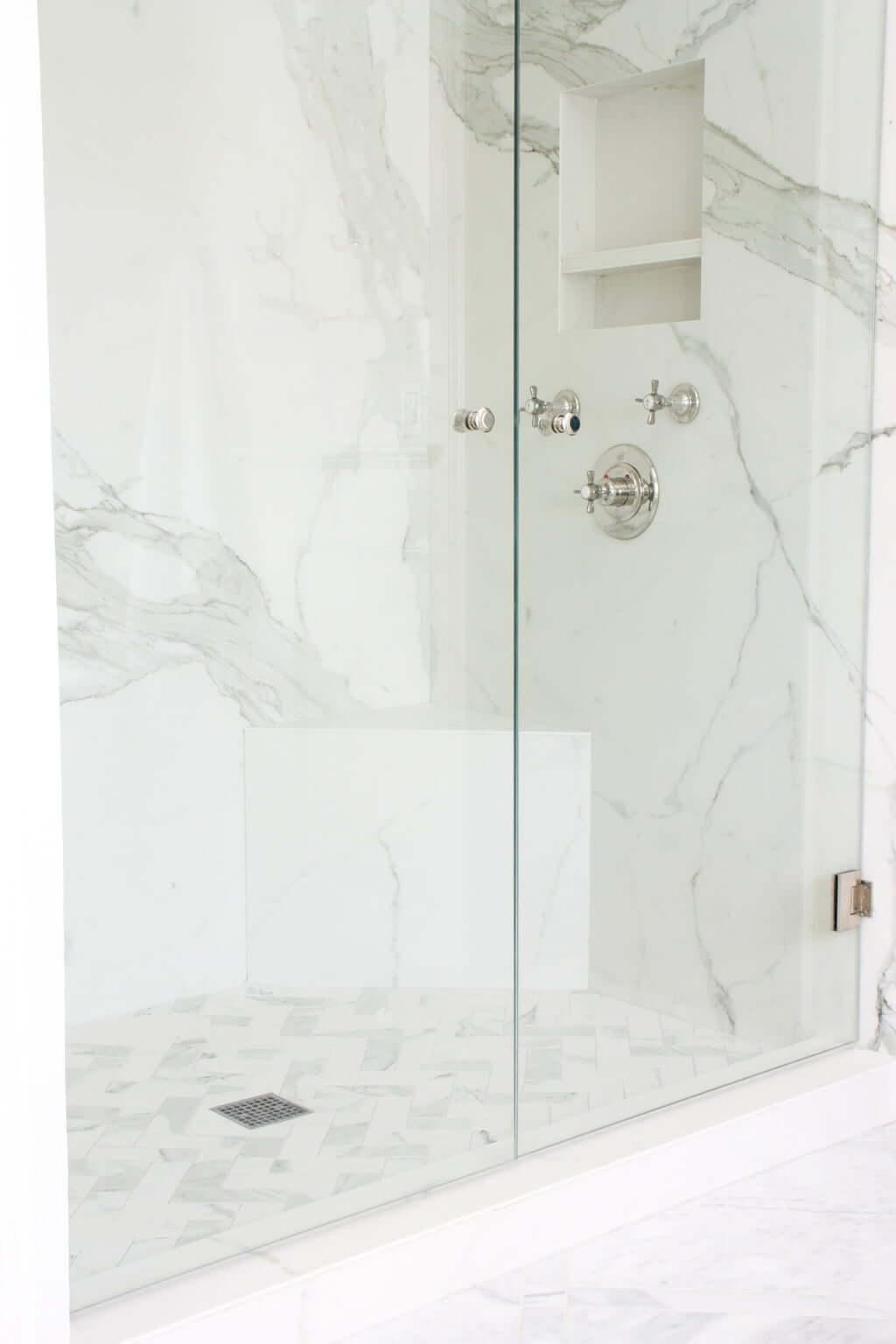 glass doors to double porcelain shower, porcelain shower shelf with hardware below