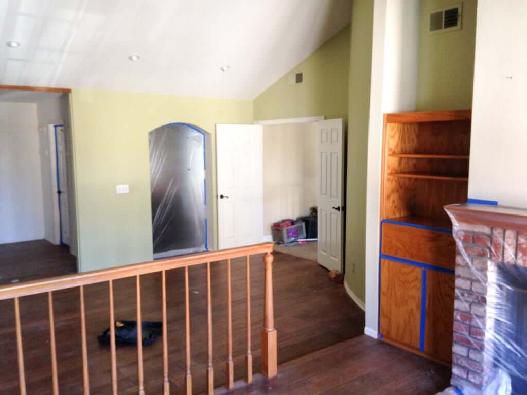 view of bedroom area from sitting area, wood railing inbetween