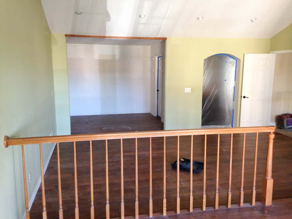 view of bedroom area and opening to closet from sitting area, wood railing inbetween