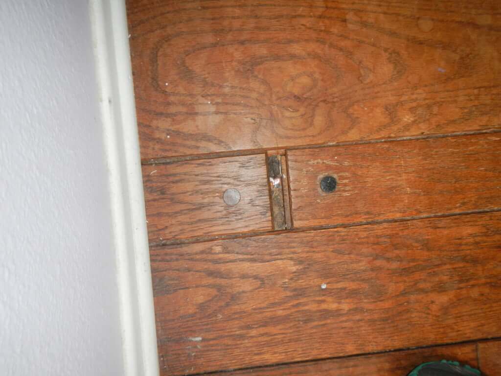 wood floor in need of repair, missing wood section