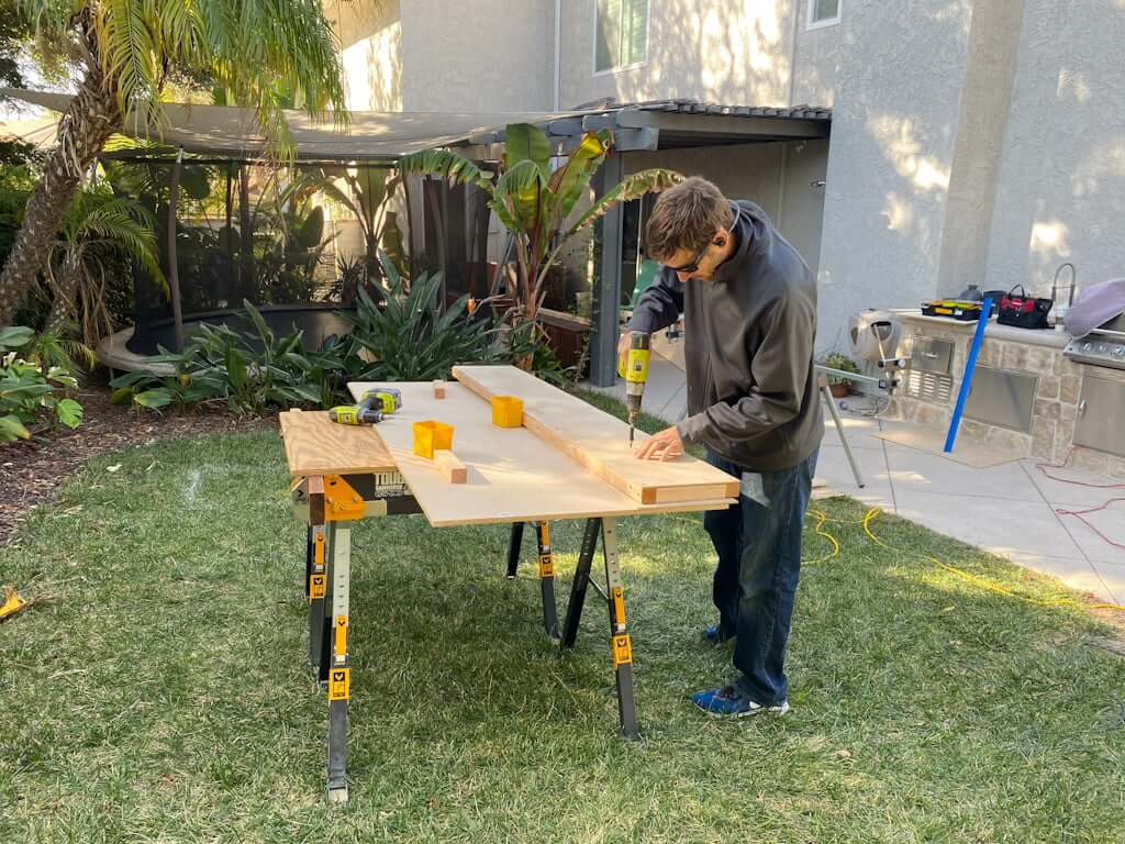 man building DIY platform bed footboard