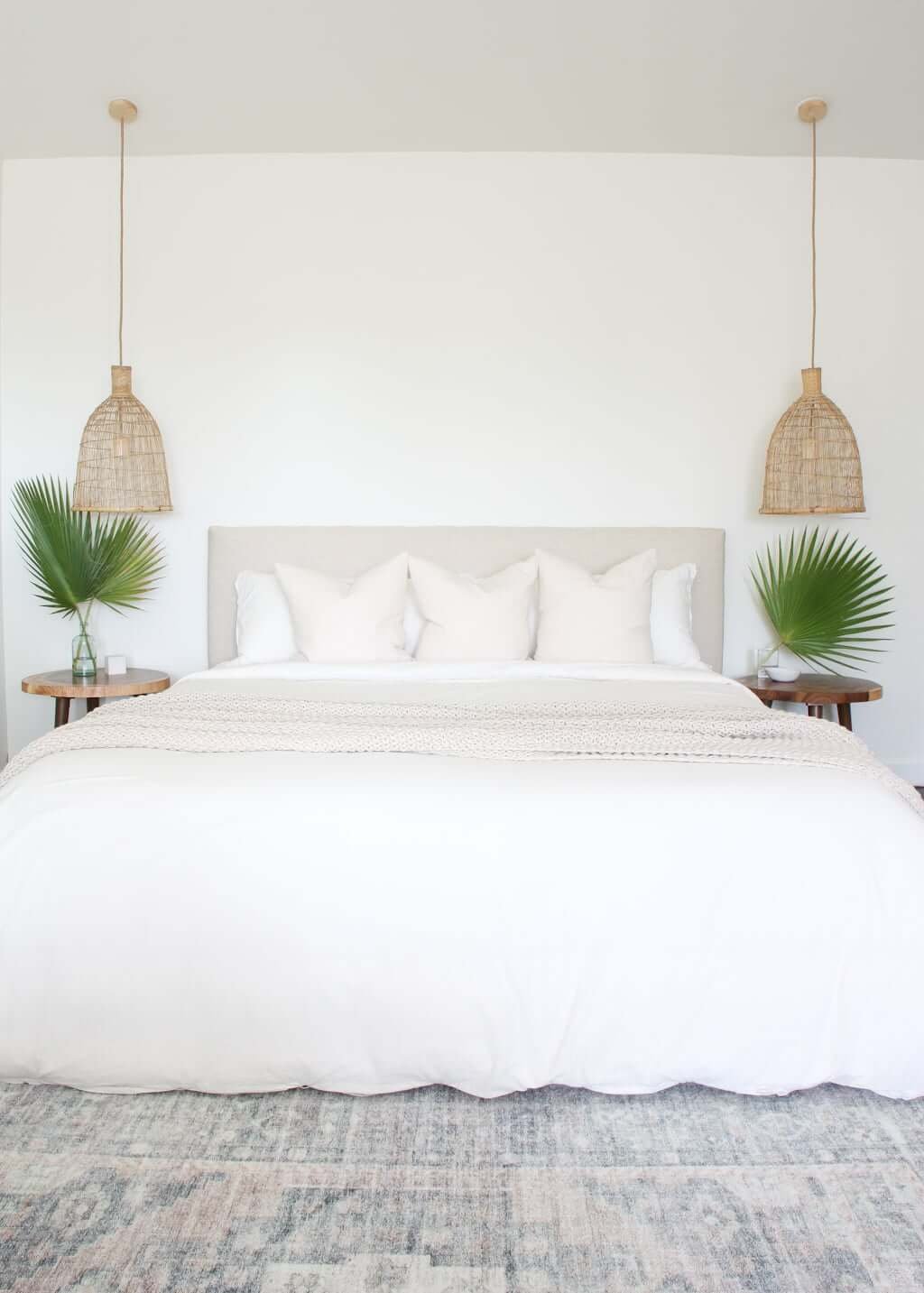 upholstered bed with woven side pendants and nothing hanging above bed