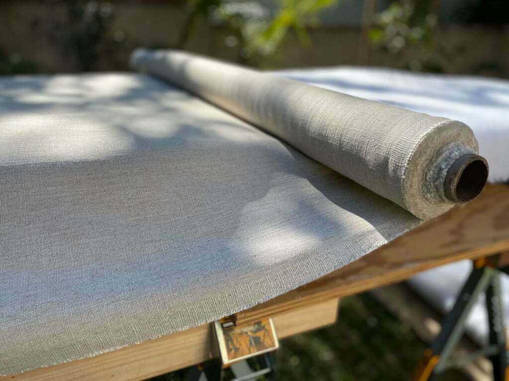 fabric rolled out on DIY headboard for soft platform bed 