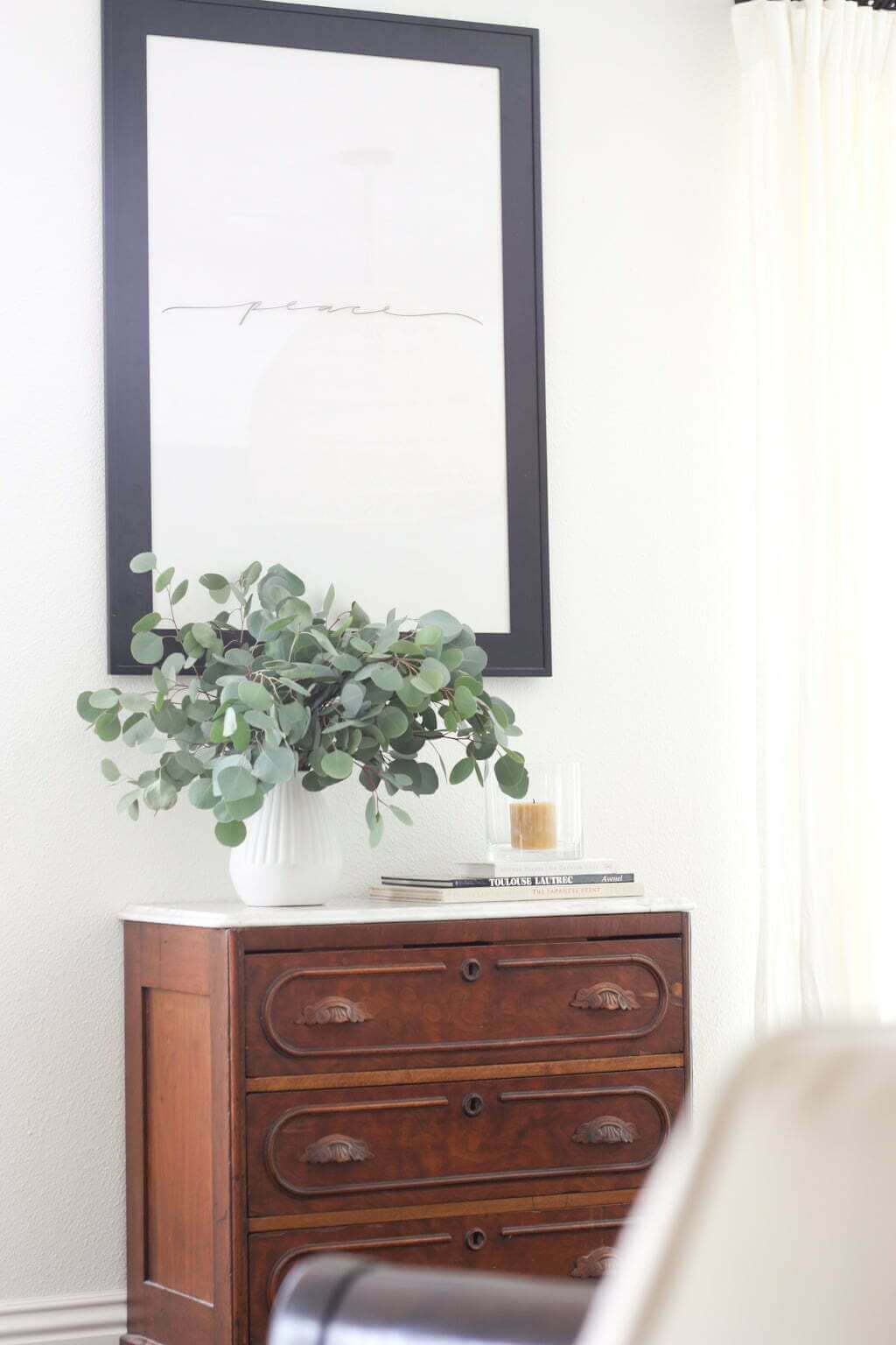 antique dresser with eucalyptus and candle on top