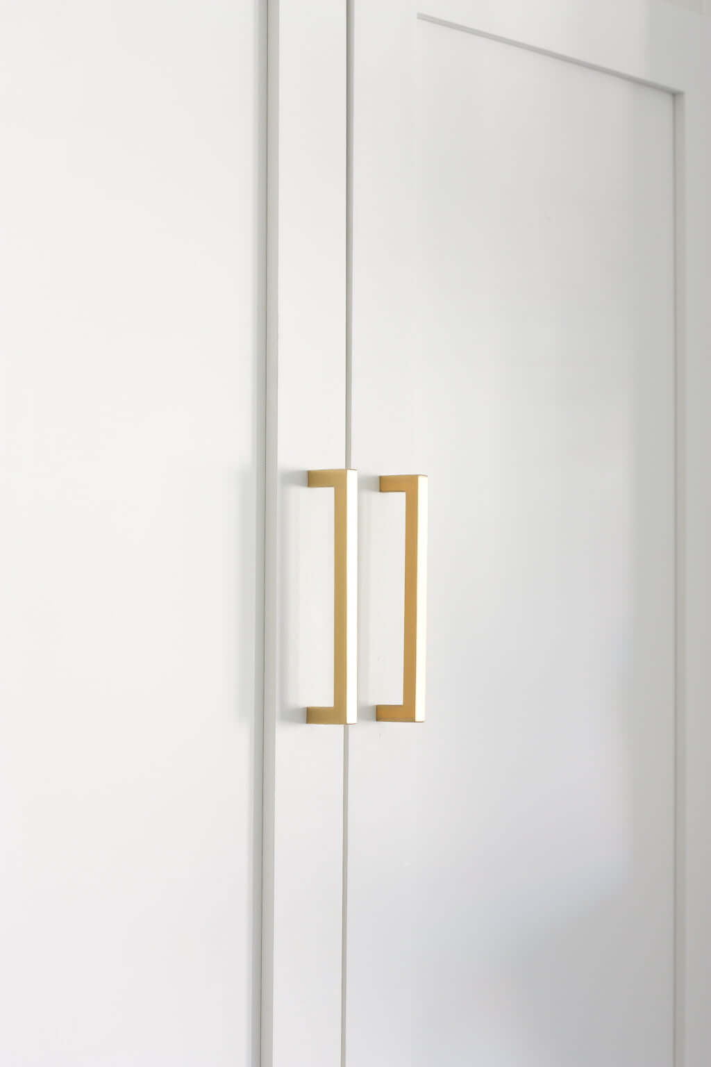 modern brass hardware on white shaker cabinet doors