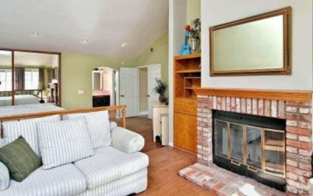 fireplace in bedroom with bookcase and sofa