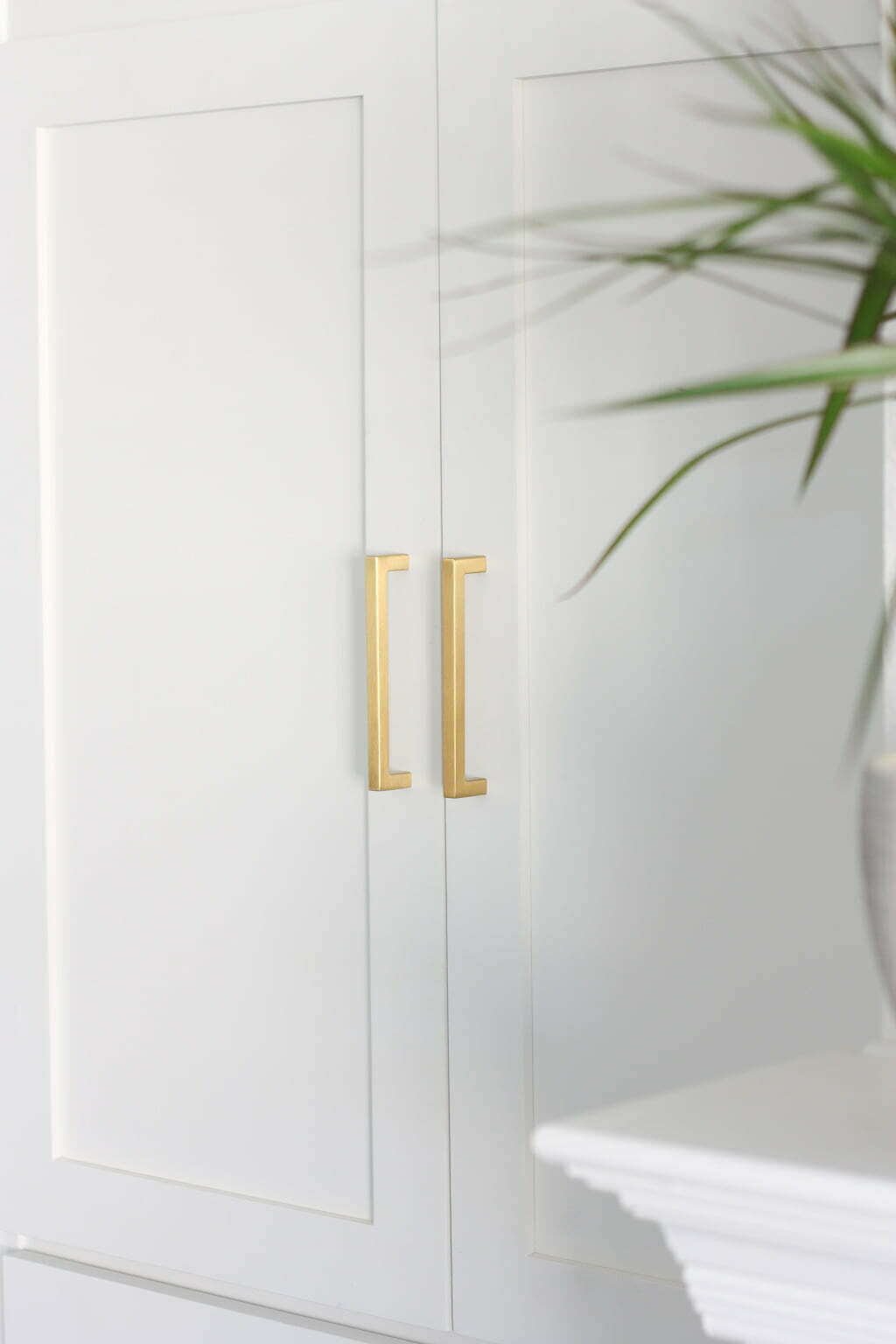 DIY bookcase makover with white shaker cabinet doors with brass hardware