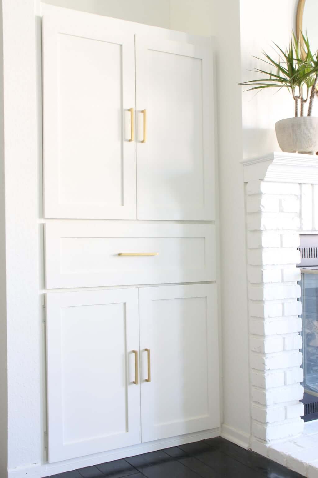 DIY bookcase makeover with white doors, drawer, and brass hardware