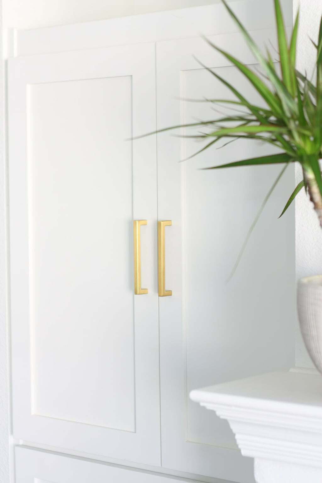 DIY bookcase makeover with white shaker cabinet doors and brass pulls