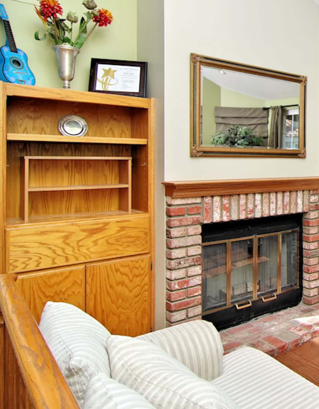 wood built in bookshelves next to brick fireplace