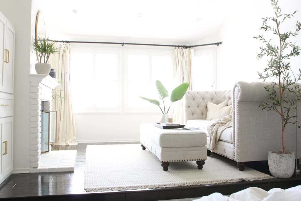 master bedroom sitting area with fireplace, couch and ottoman