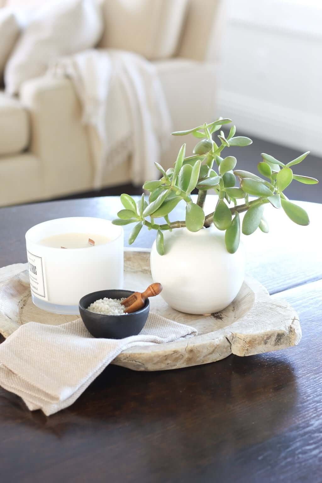 wood tray on dining table with bud vase, candle, and salt scooper