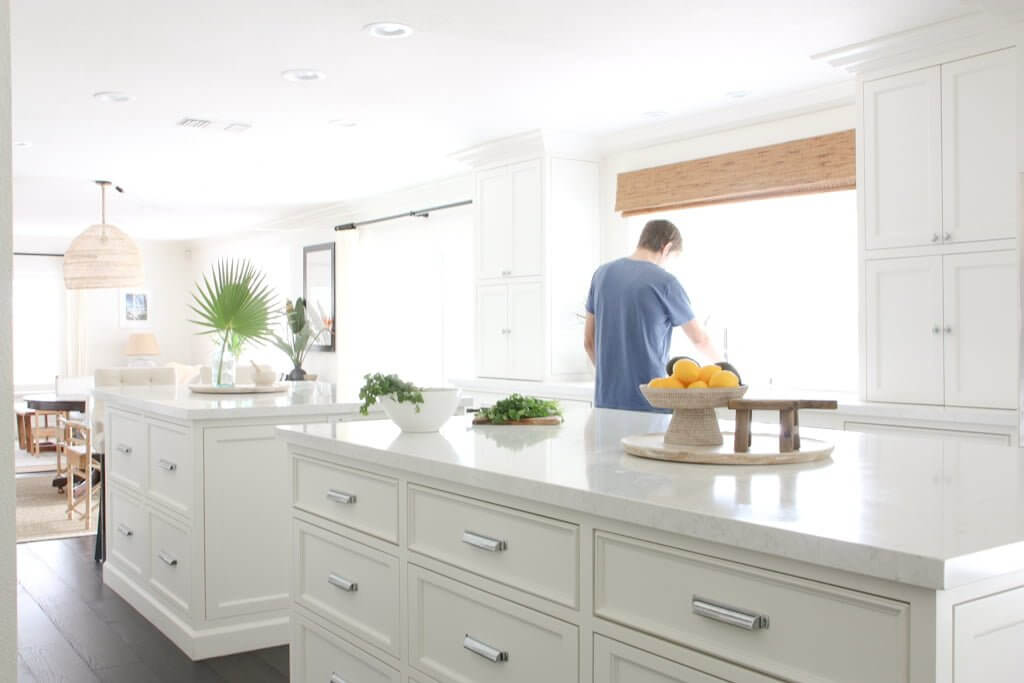 man at kitchen sink with double islands and kitchen drawers below