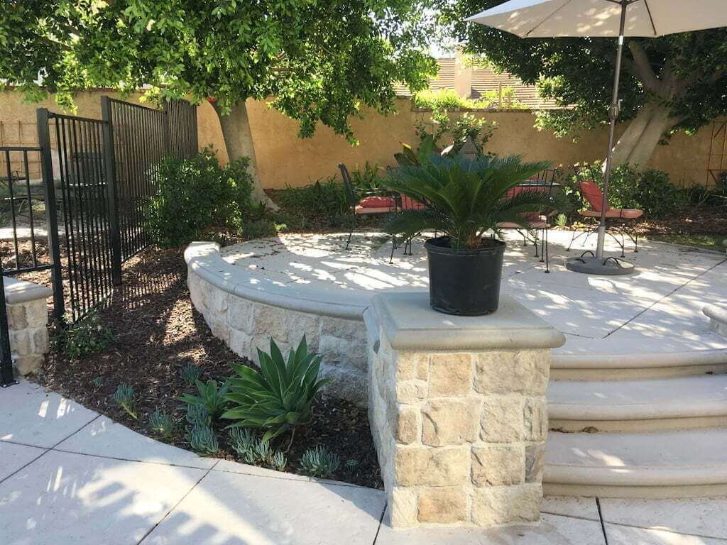 raised concrete patio with steps and plants along the patio edge