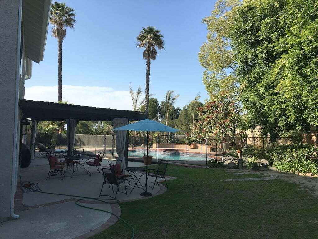 backyard with lawn, concrete patio, arbor pergola and pool