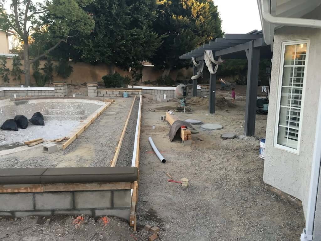 backyard with raised patios and levels with pool, concrete blocks and raised patio with retaining wall 