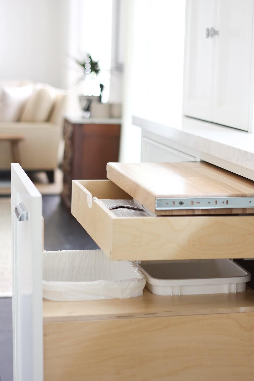 slide out cutting board drawer above garbage can, with extra kitchen storage drawer below