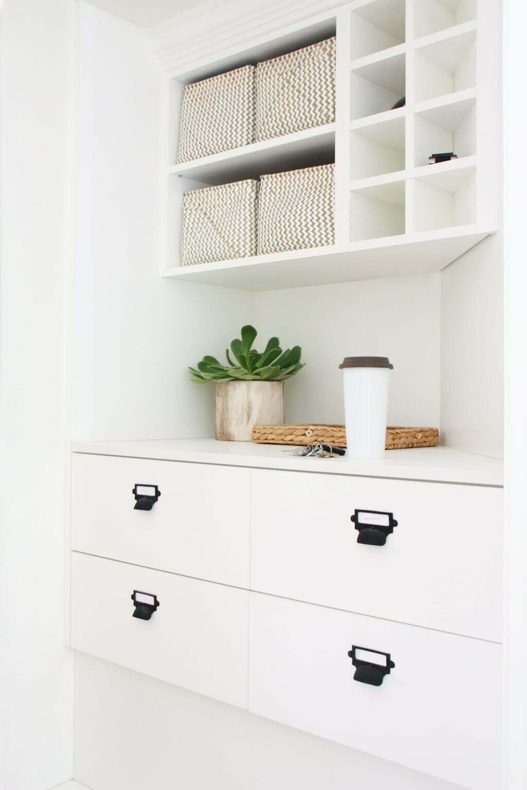 white entryway drop zone with drawers, countertop, shelves with baskets