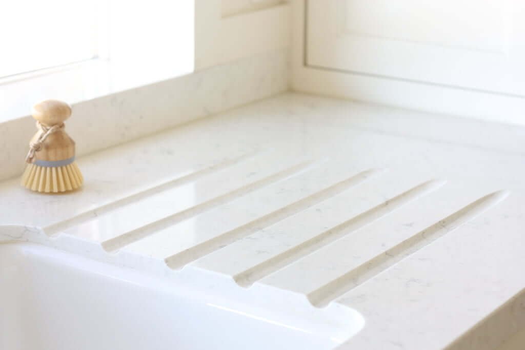 built in countertop drainboard in white quartz next to sink