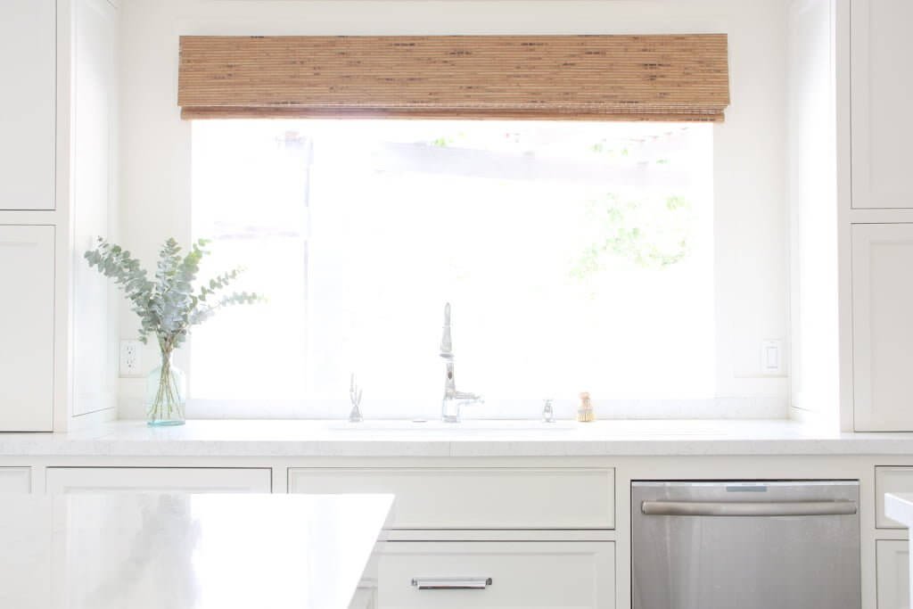 kitchen sink with large window and quartz countertops