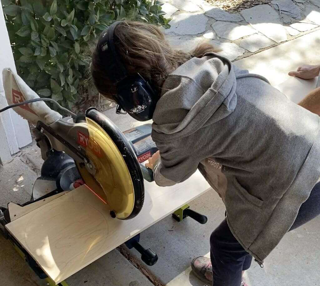 girl operating saw for wood cutting board