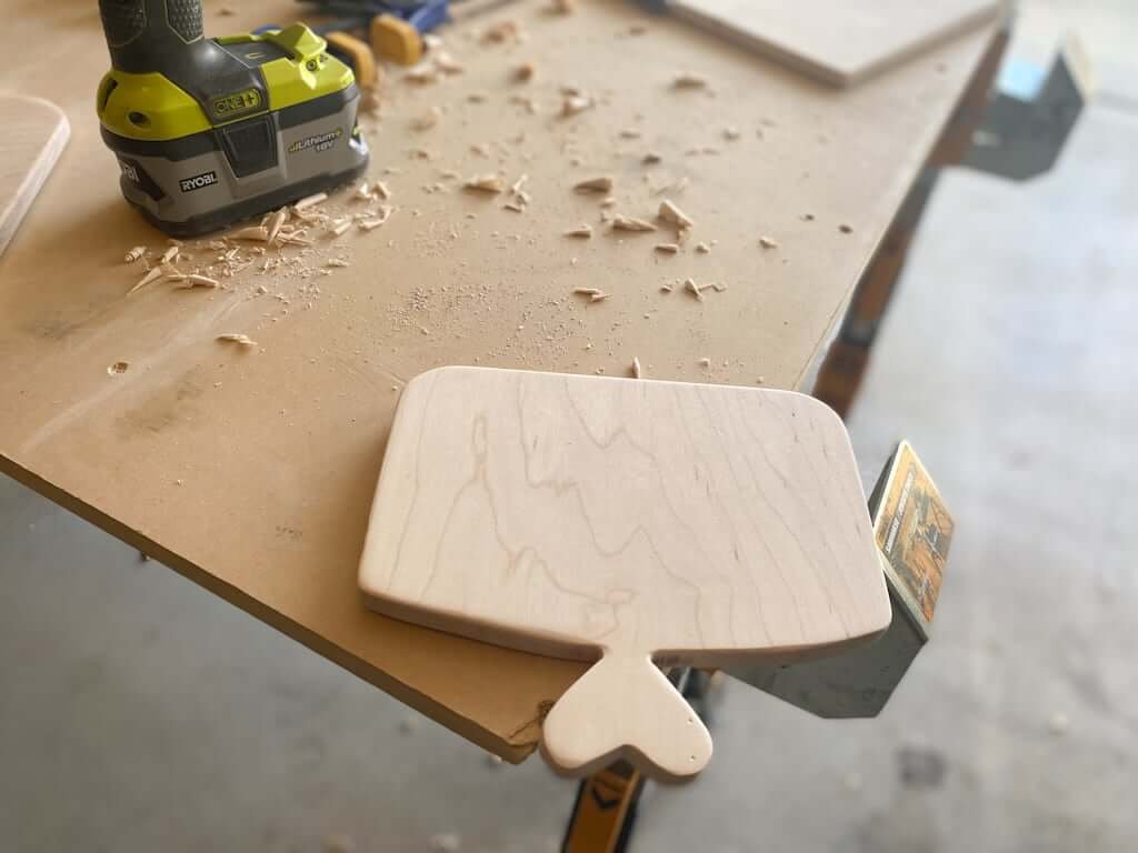 DIY cutting board with heart-shaped handle on worktable