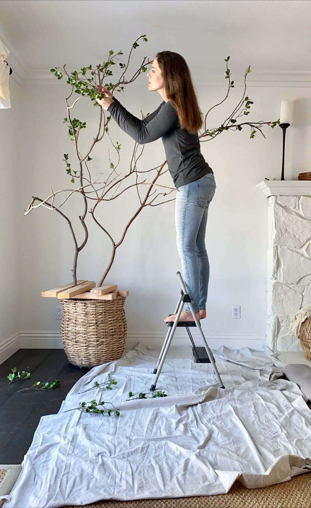 woman making a fake tree with artificial tree branches