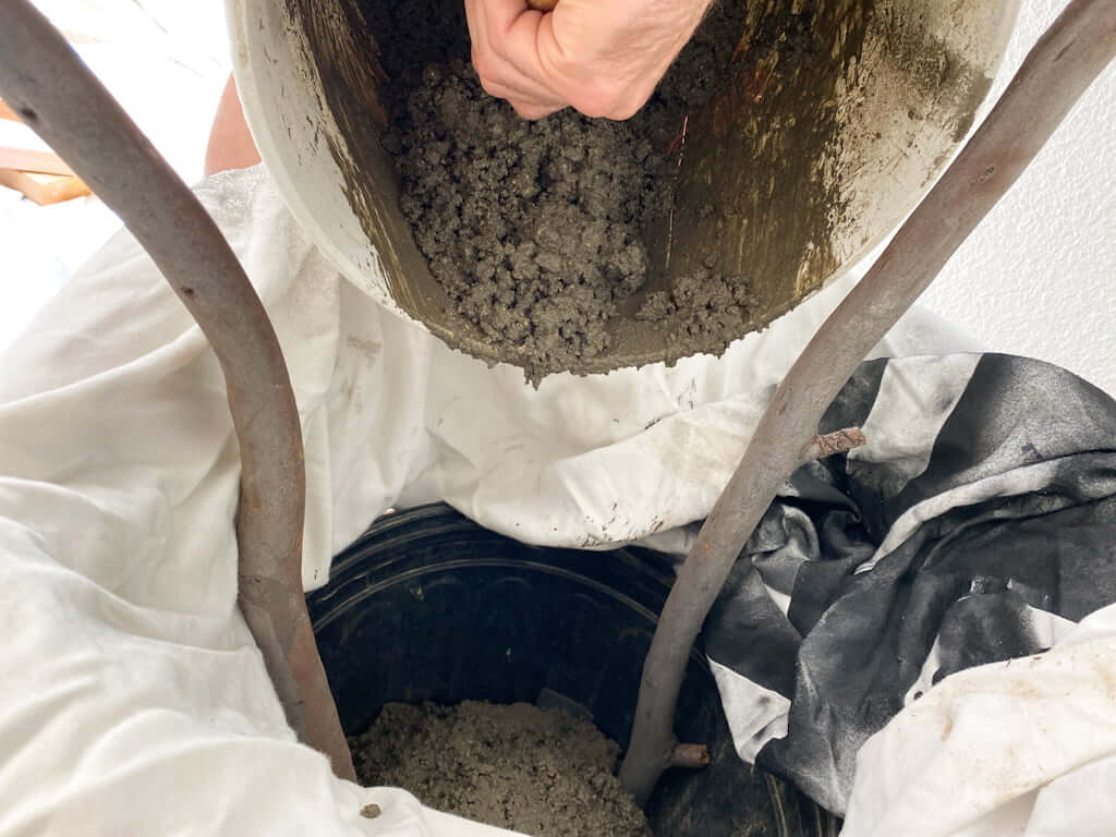 hand scraping concrete into faux tree branch bucket