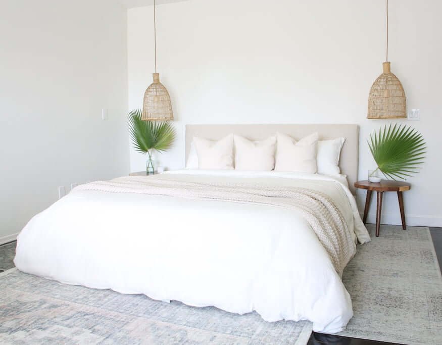 luxury hotel style bedroom with woven pendants and wood stool nightstands