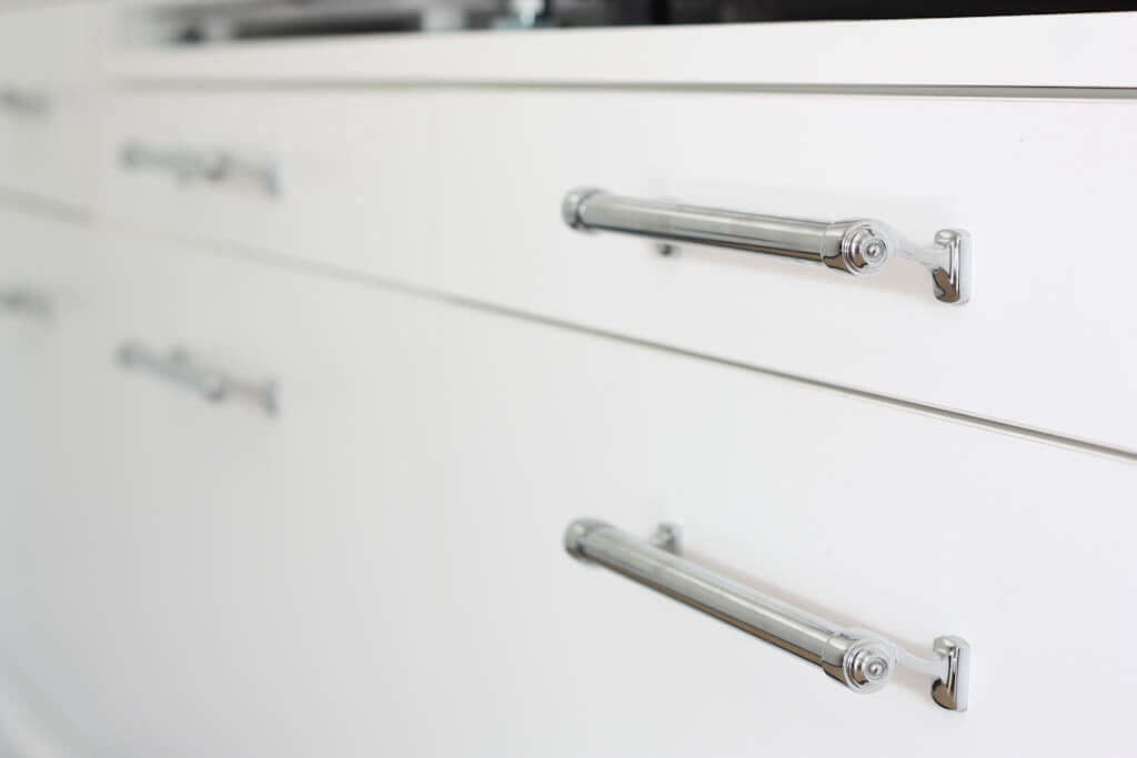 chrome pulls on small laundry room drawers and shelves