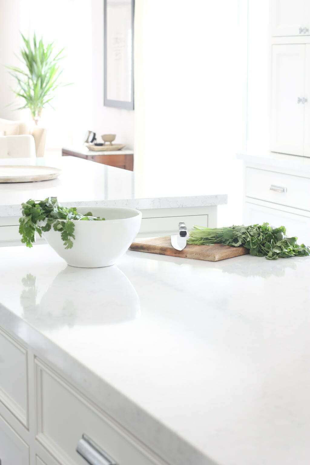 white quartz countertops on white kitchen island with cilantro being chopped