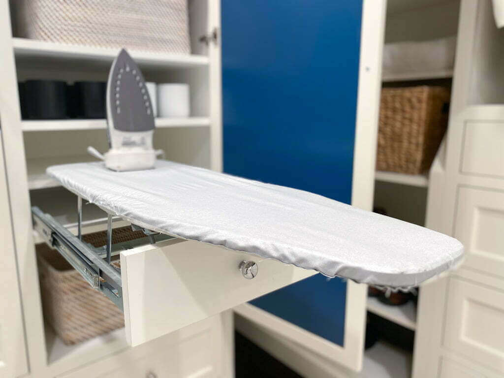 built in ironing board drawer in cabinet in closet, folded out with iron on top
