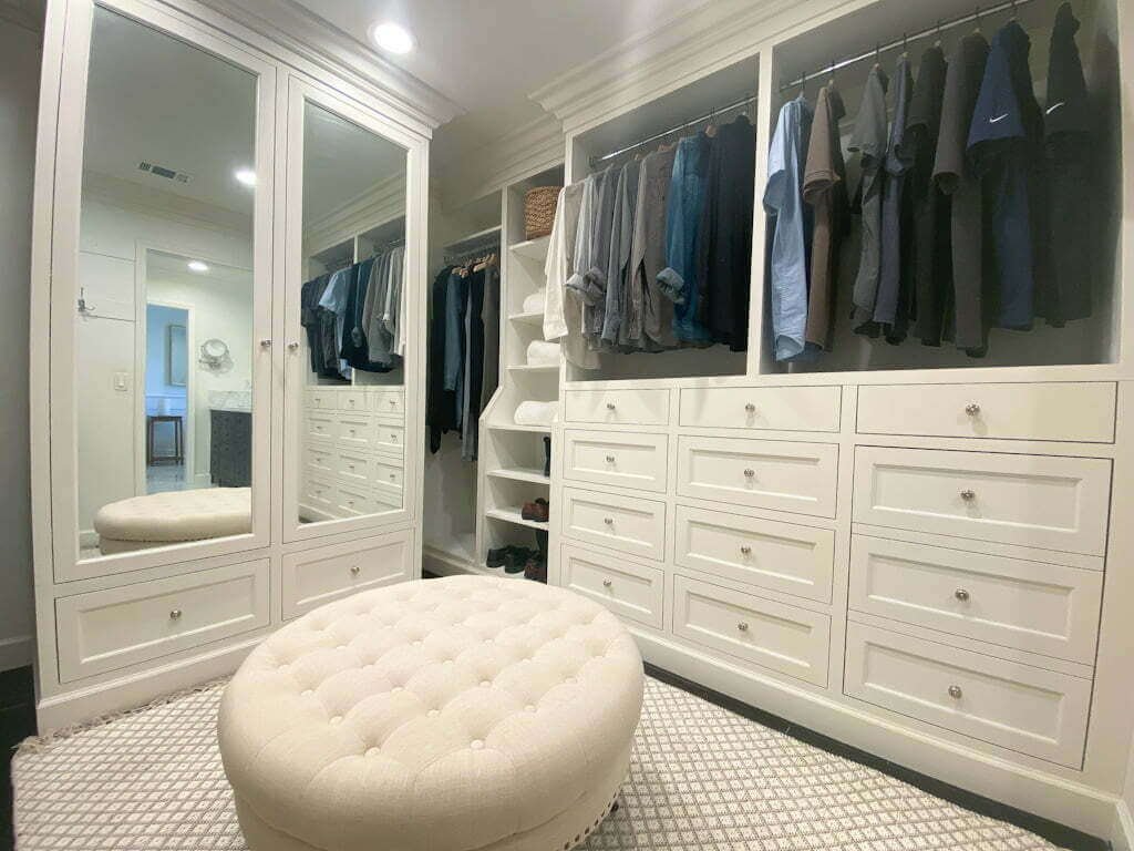 walk in closet with hanging space, cabinet, and drawers with hidden hamper cabinet