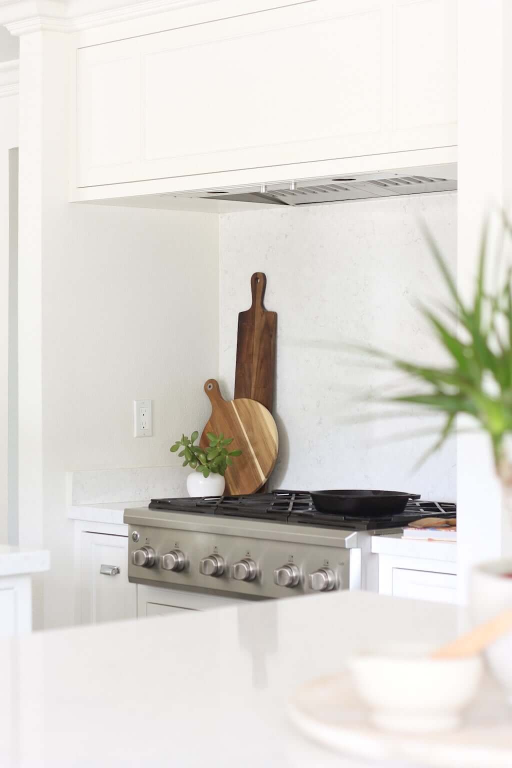 white kitchen with quartz backsplash behind stove only