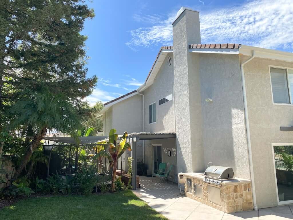 backyard with outdoor kitchen, trampoline, and outdoor shower