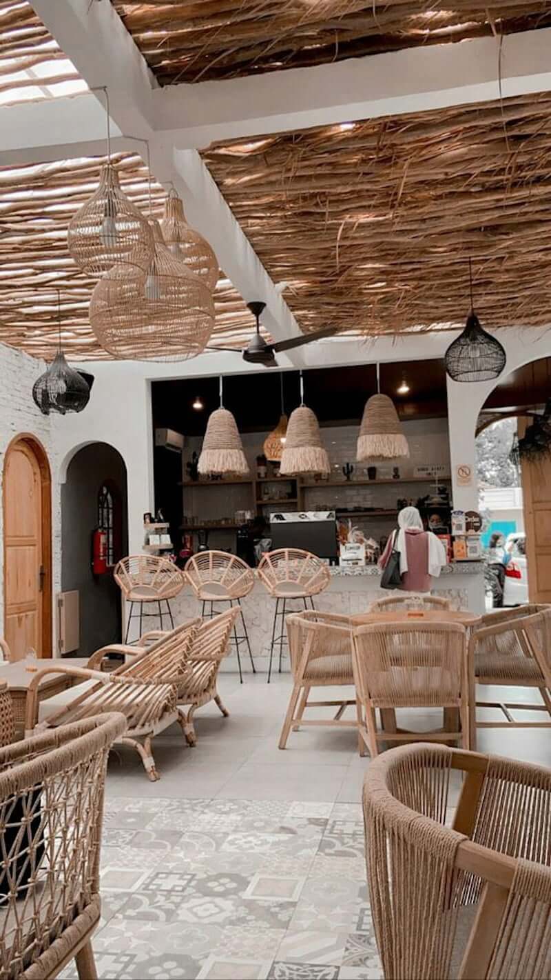 outdoor bar with wood stick roof and woven malawi chairs and natural woven pendants