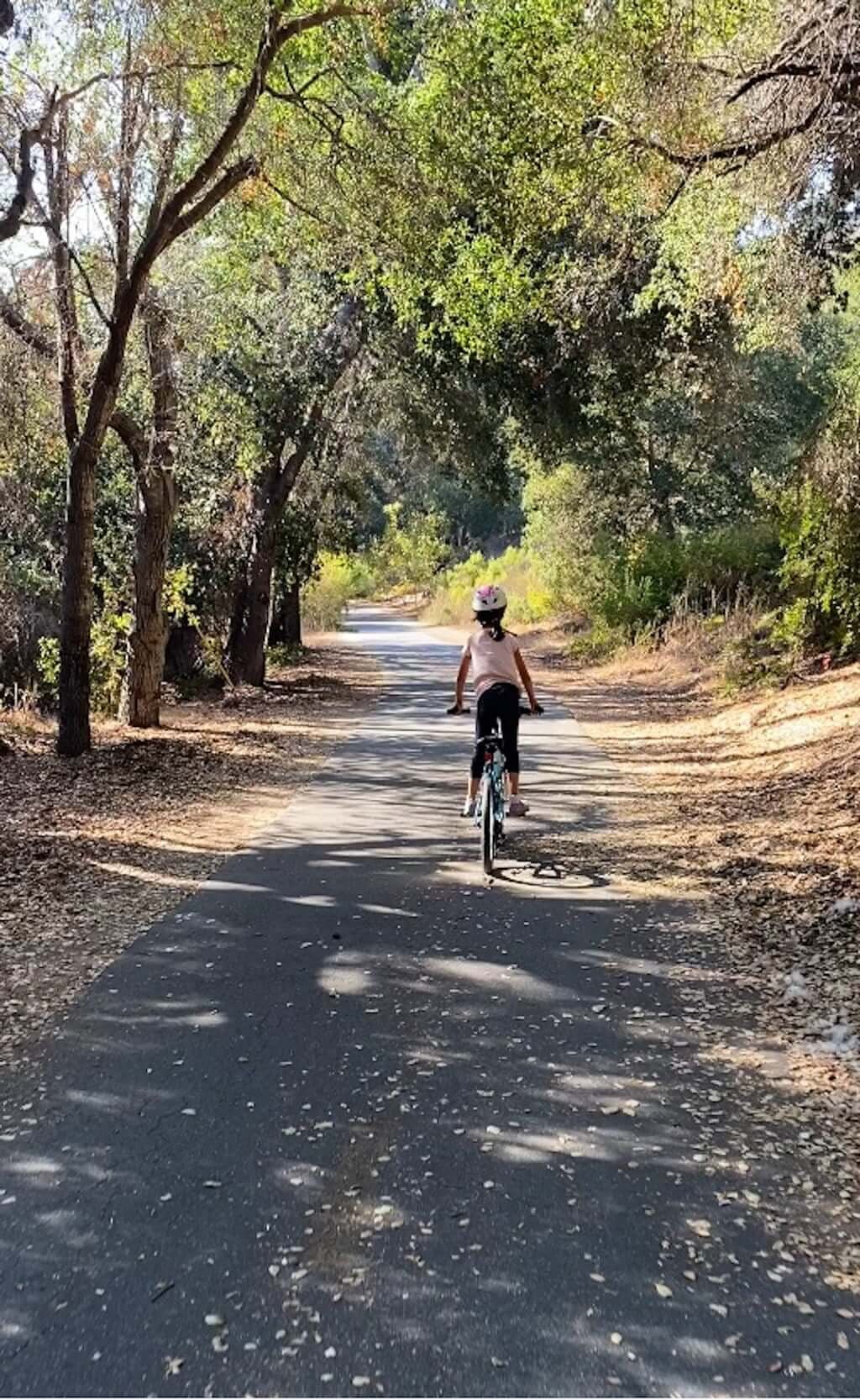 girl biking the Bob Jones Trail to Avila Beach with fall leaves