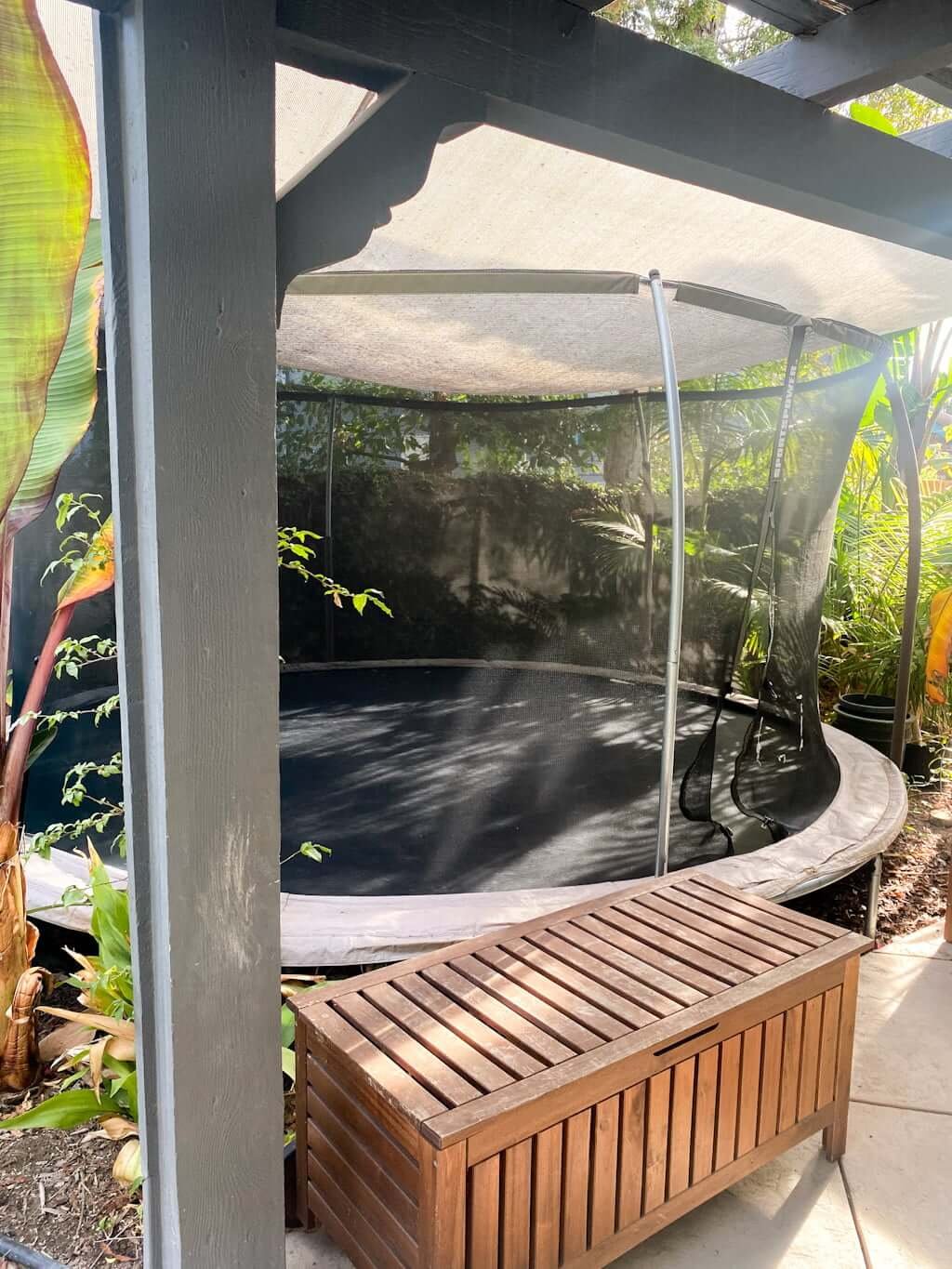 in-ground trampoline DIY with net and sail shade above