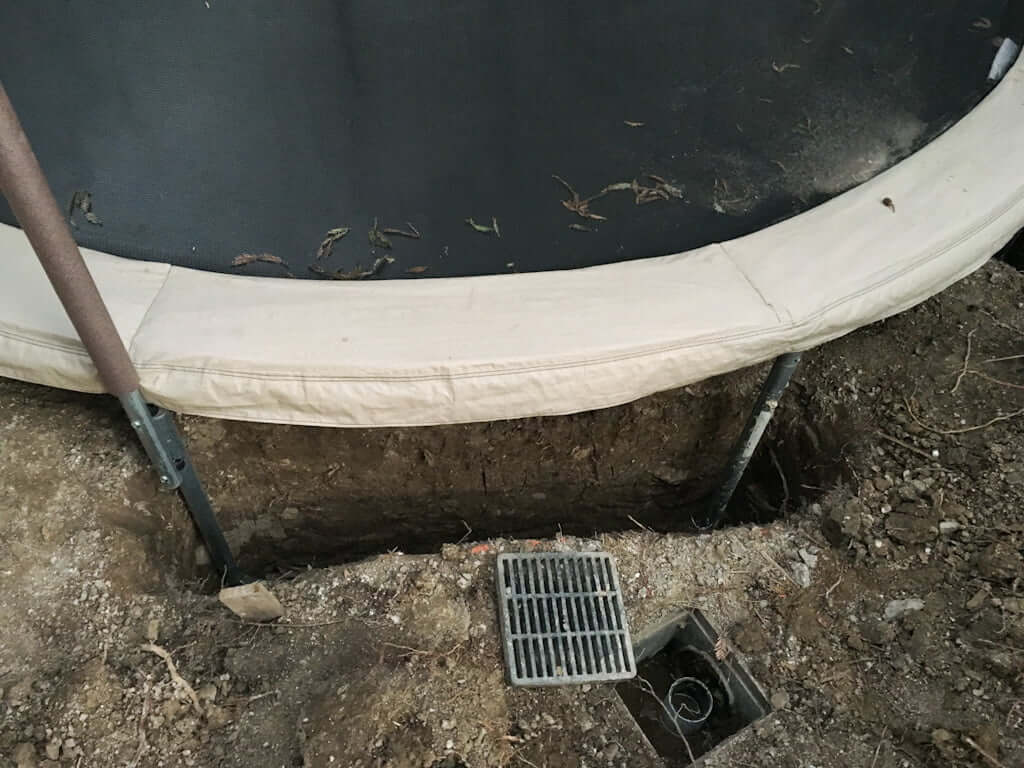 sunken trampoline being put in ground holes for drainage