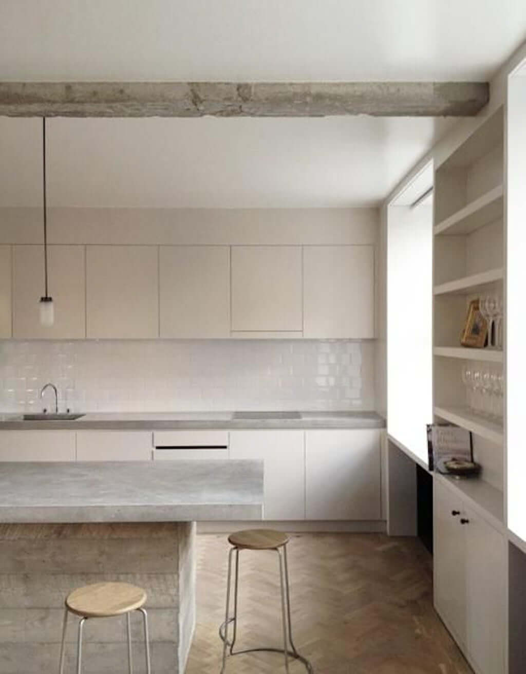 grey concrete kitchen island with cream cabinets